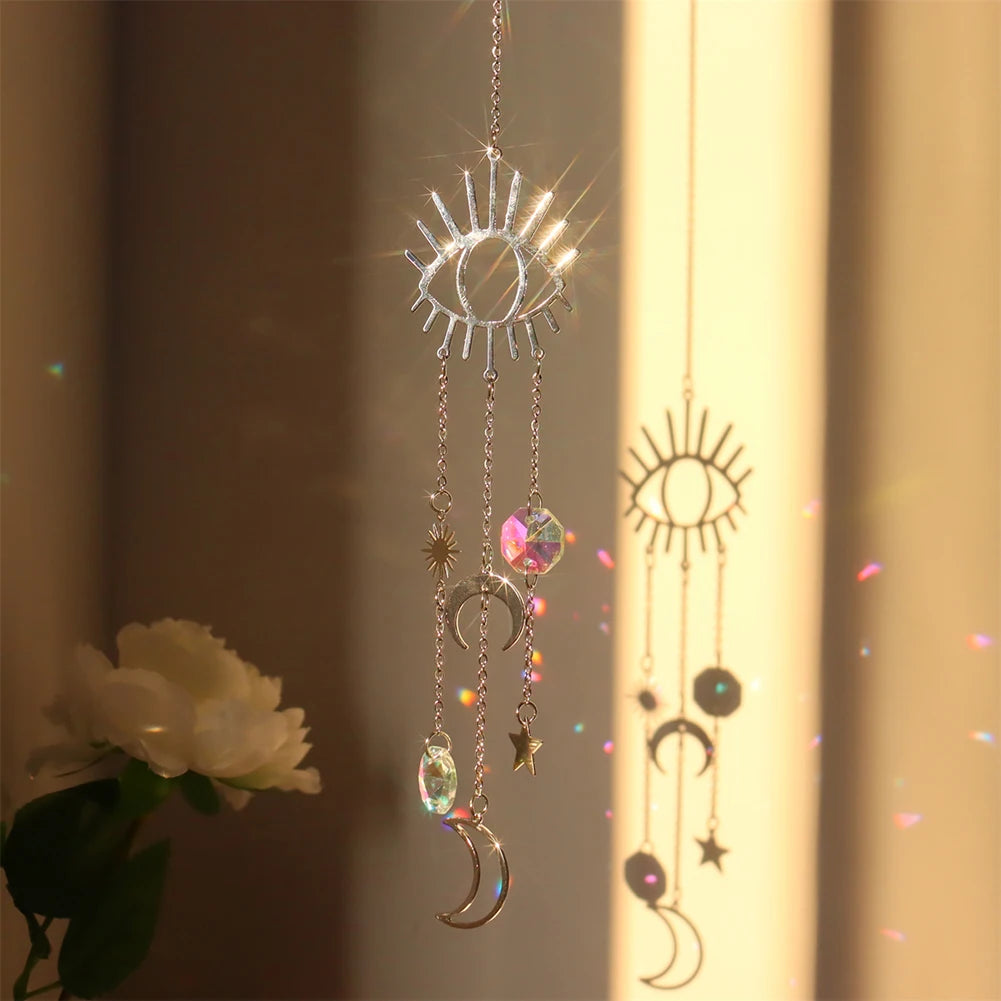 Decorative hanging with sun, moon, and star charms in front of a light curtain.