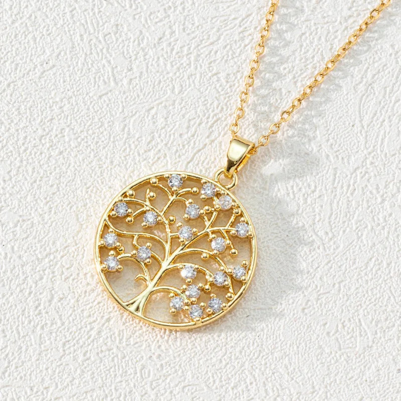 Gold necklace with a tree-of-life pendant on a light gray background