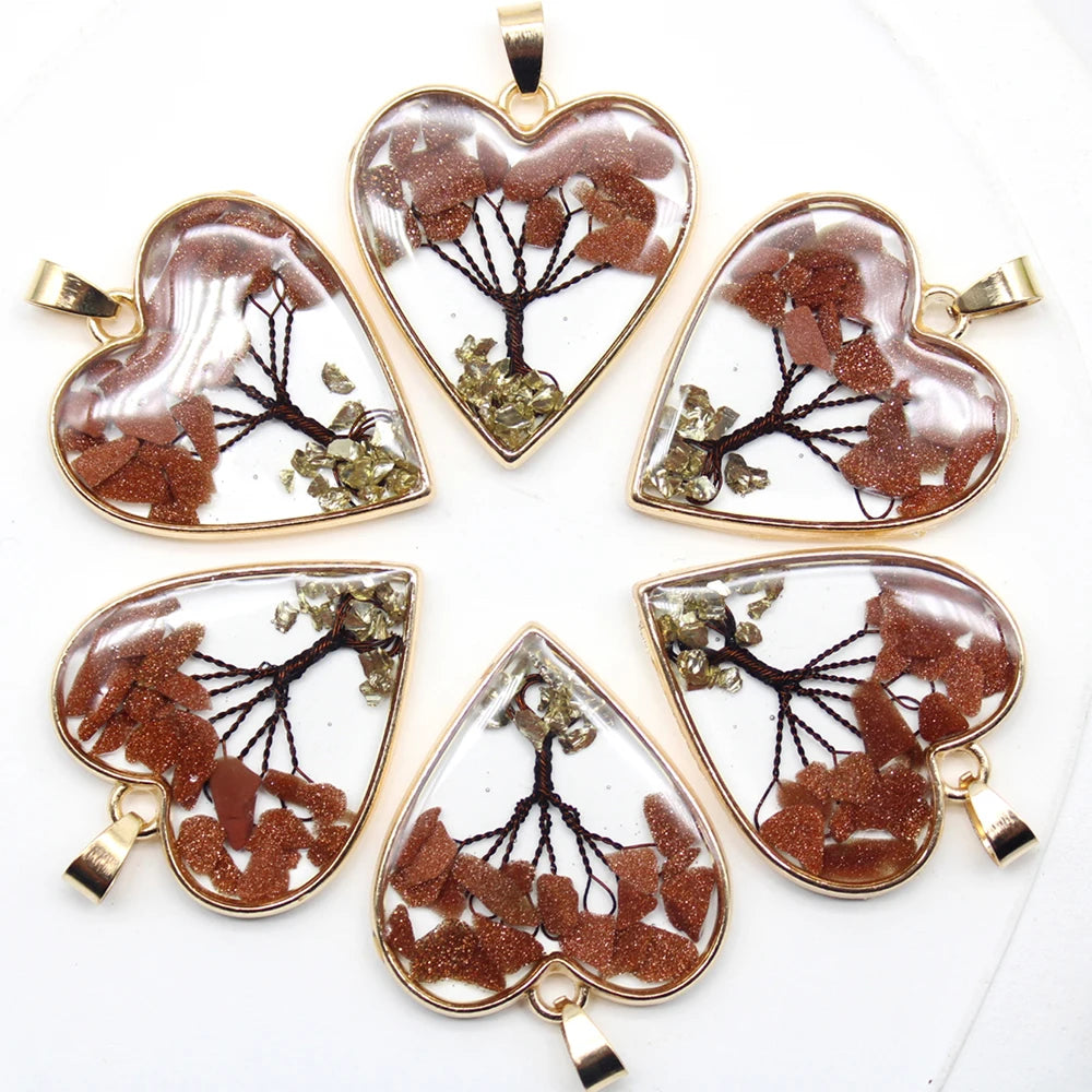 Heart-shaped pendants with tree designs on a white background