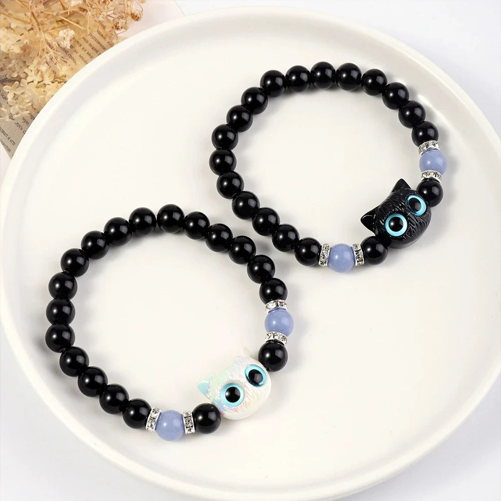 Black beaded bracelet with owl charm on a white plate