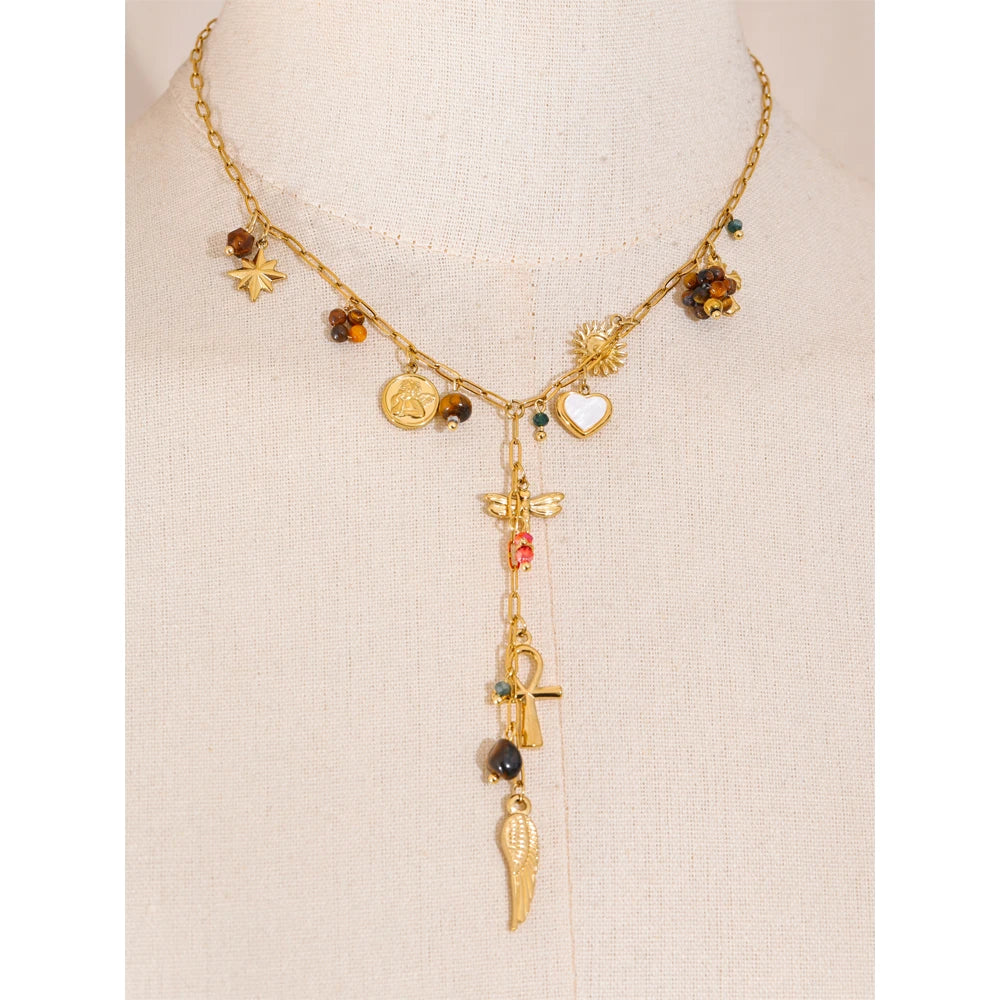 Gold necklace with various charms on a beige background