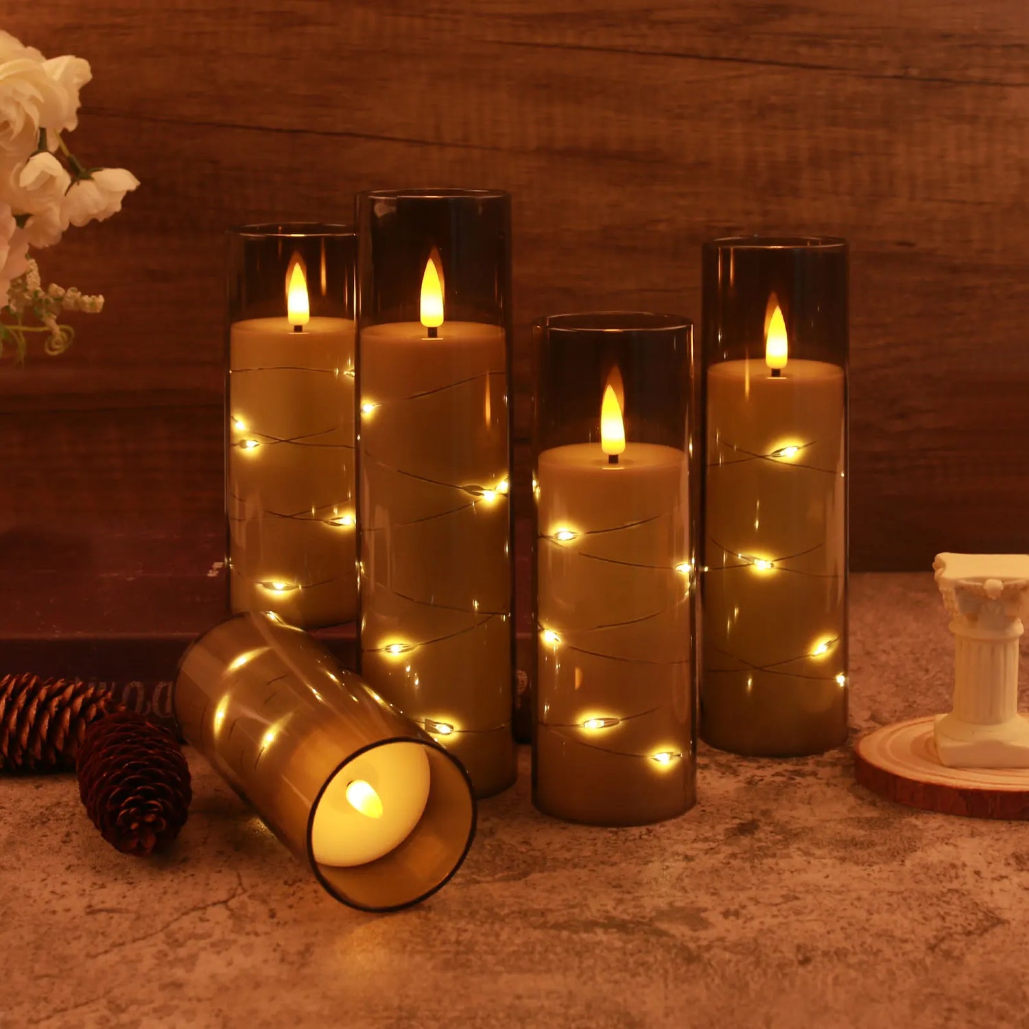 Decorative candles with string lights on a wooden surface