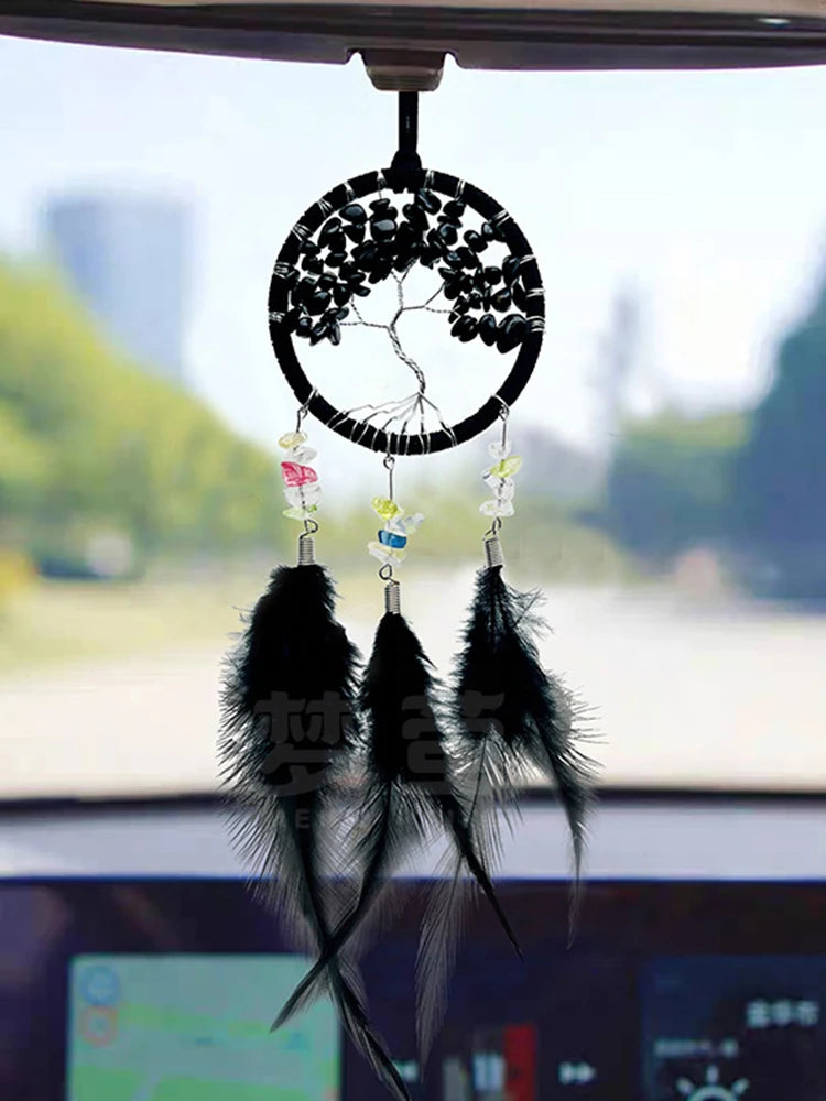 Car dashboard with a black feathered dreamcatcher ornament.