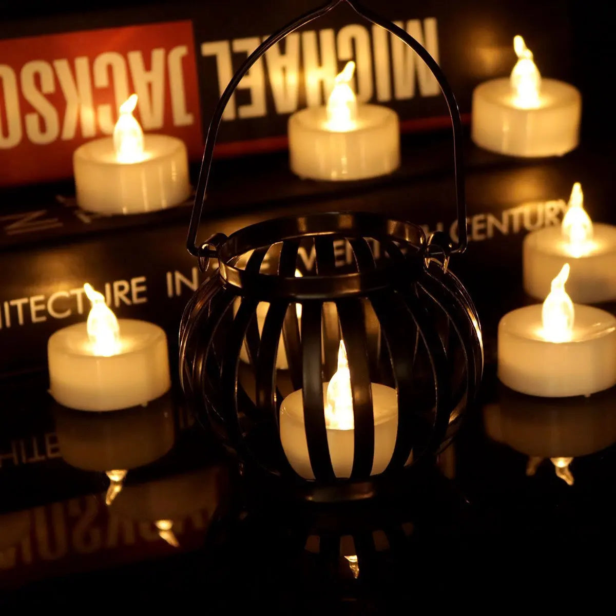 Black metal lantern with lit candles on a magazine background