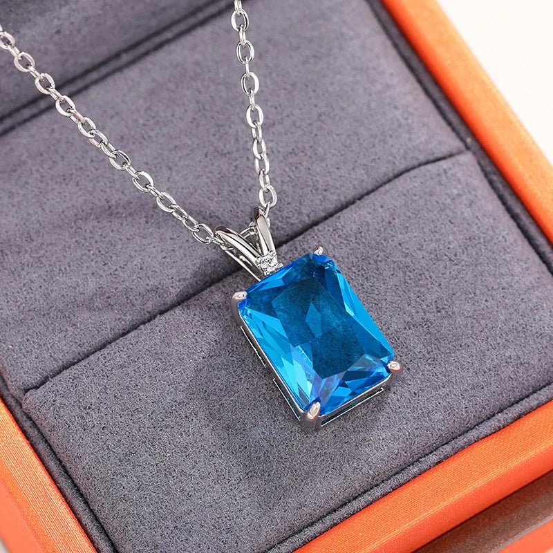 Blue gemstone necklace on a gray cushion with an orange border