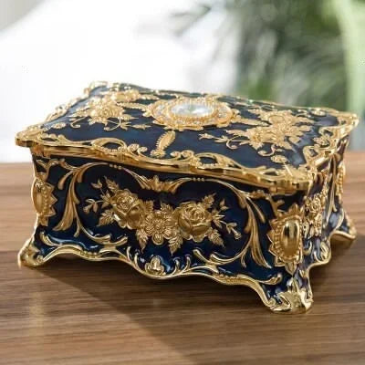 Decorative box with gold embellishments on a wooden surface