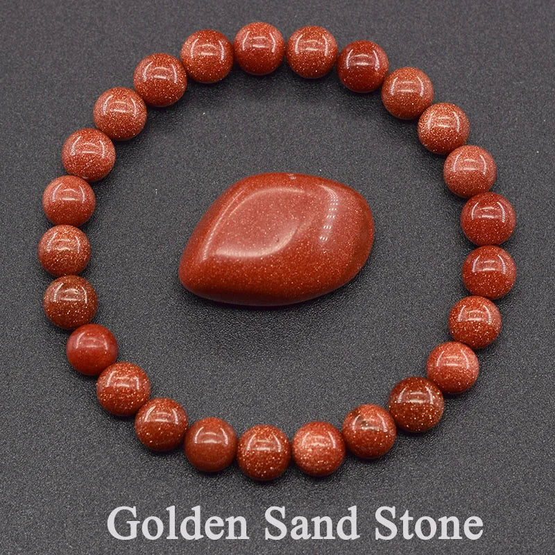 Bracelet made of red stones with a central stone on a gray background, labeled 'Golden Sand Stone'.