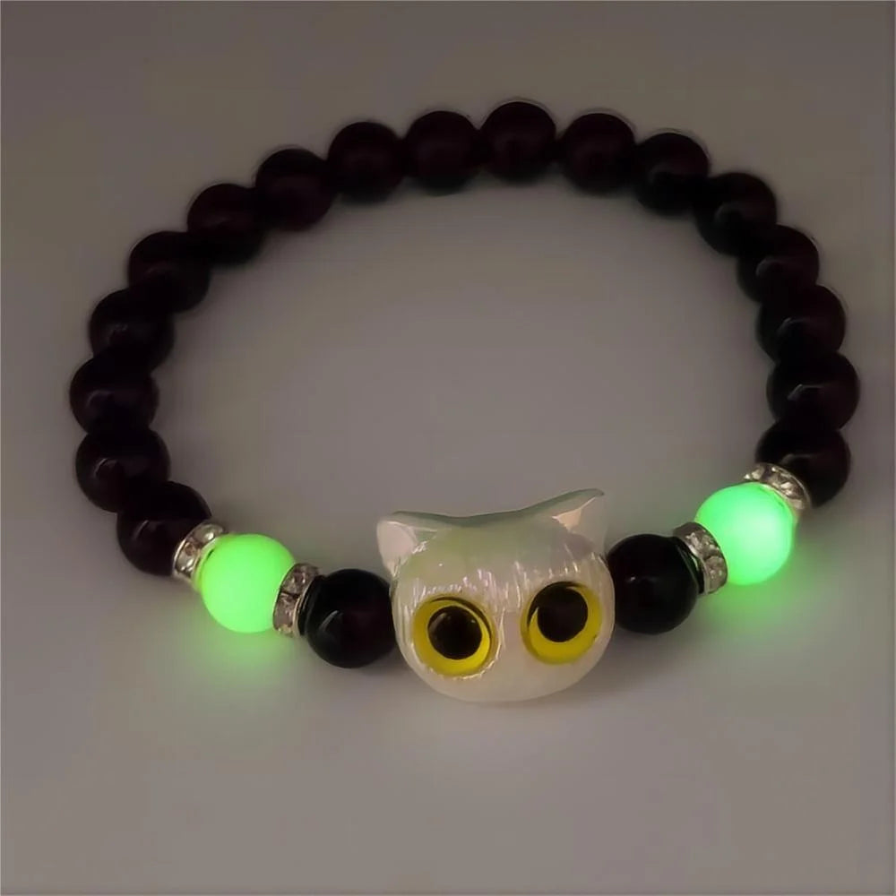 Bracelet with owl-shaped charm and green beads on a gray background