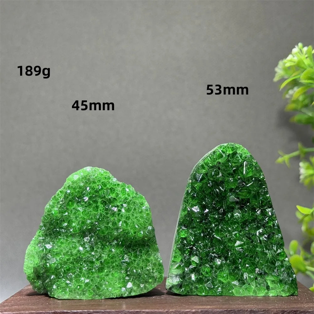 Two green crystal rocks on a wooden surface with measurements labeled.