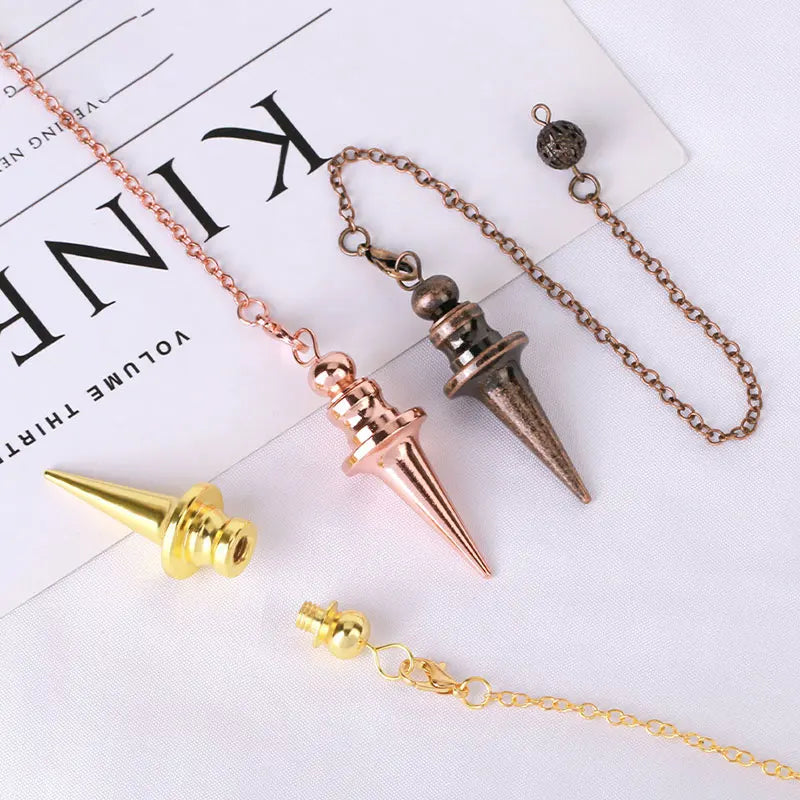 Three spiked pendants on chains with a magazine in the background