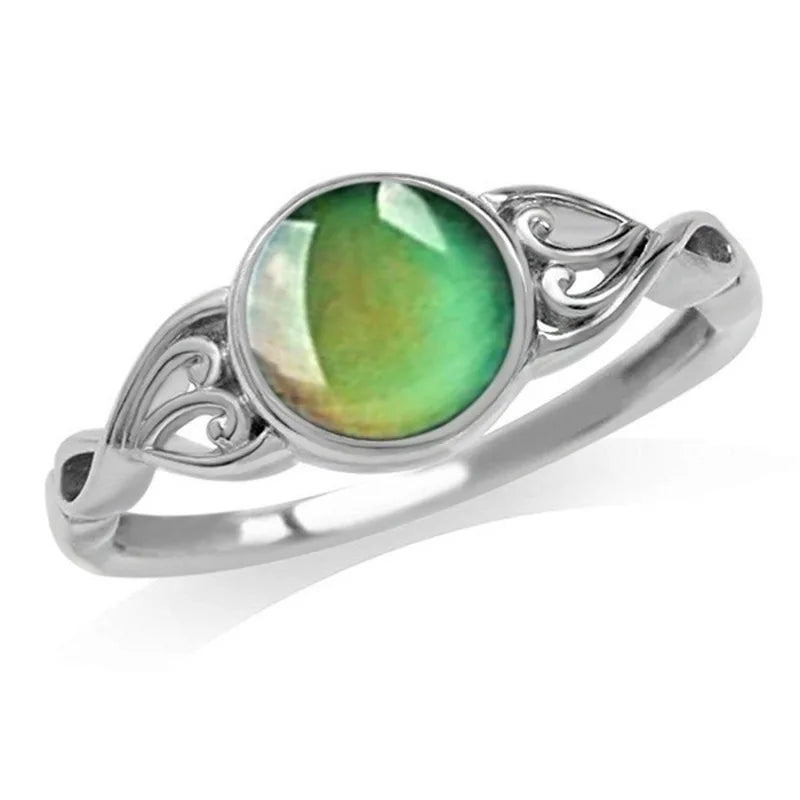Silver ring with a green gemstone on a white background