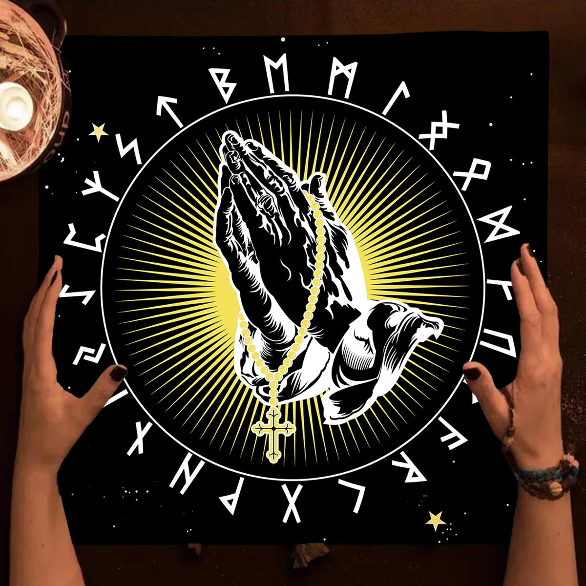 Praying hands with a rosary and a circular design with runes on a dark background.