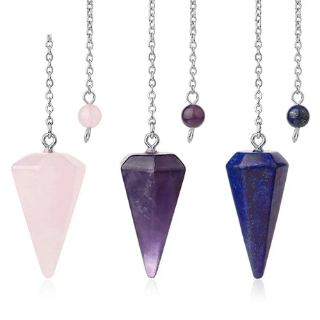Three crystal pendulums on chains with pink, purple, and blue stones against a white background.