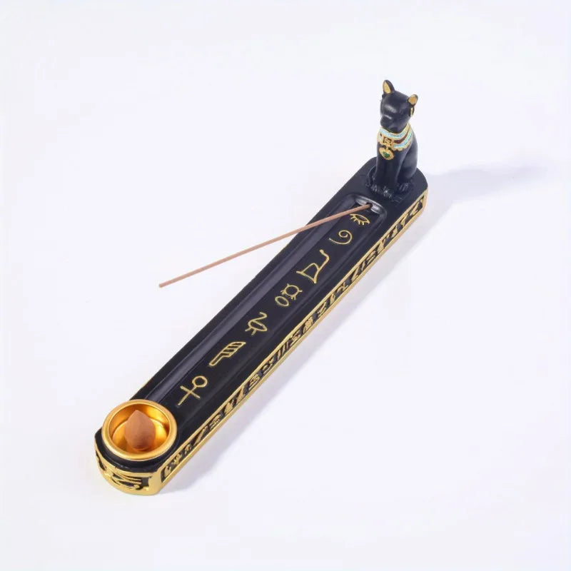 Decorative incense holder with cat figure and hieroglyphics on a white background