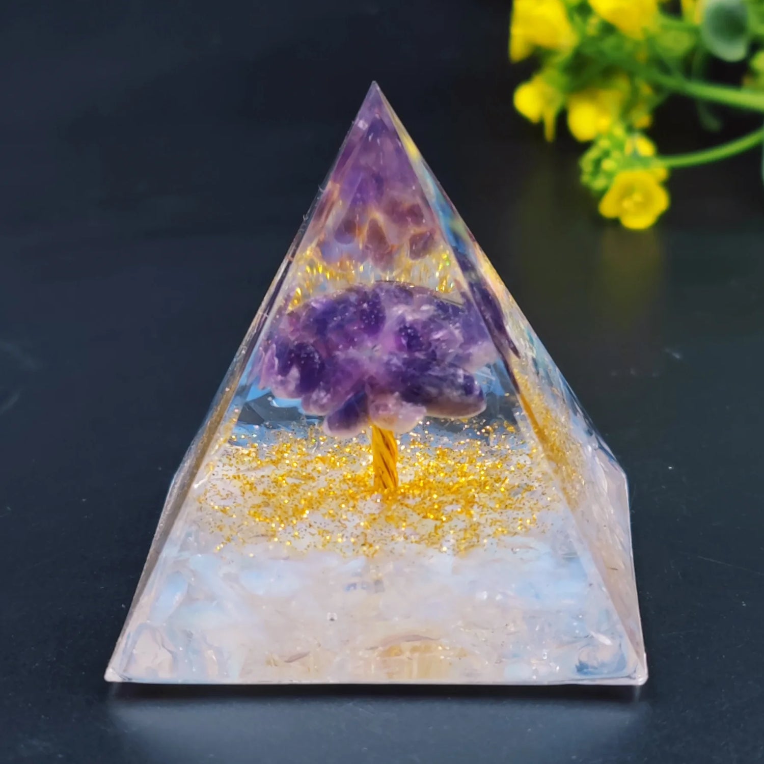 Pyramid-shaped crystal with purple crystal inside on a dark background