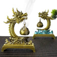 Two gold dragon-shaped incense burners on a textured surface.