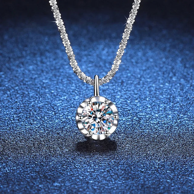 Silver necklace with a round diamond pendant on a blue textured background