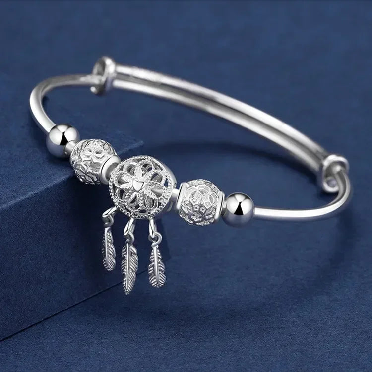 Silver bracelet with decorative beads on a blue background