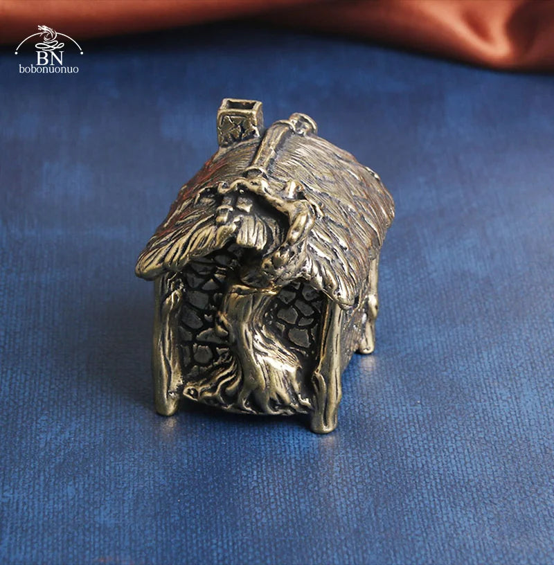 Bronze sculpture of a fairy house on a blue fabric background