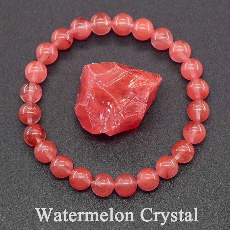 Red beaded bracelet with a watermelon crystal on a gray background