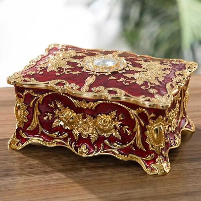 Decorative red and gold box with intricate designs on a wooden surface