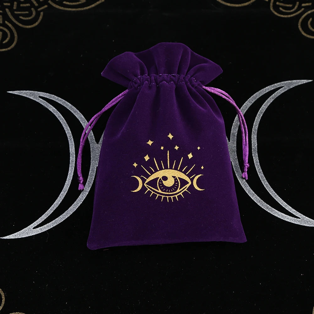 Purple drawstring bag with a gold eye symbol on a black background with moon designs.