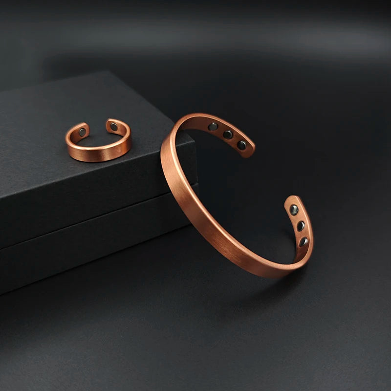 Copper bracelet and ring on a dark surface