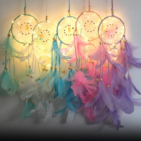 Colorful dreamcatchers with feathers and lights on a white background