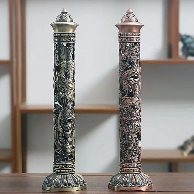Two ornate incense holders with dragon designs on a wooden surface.