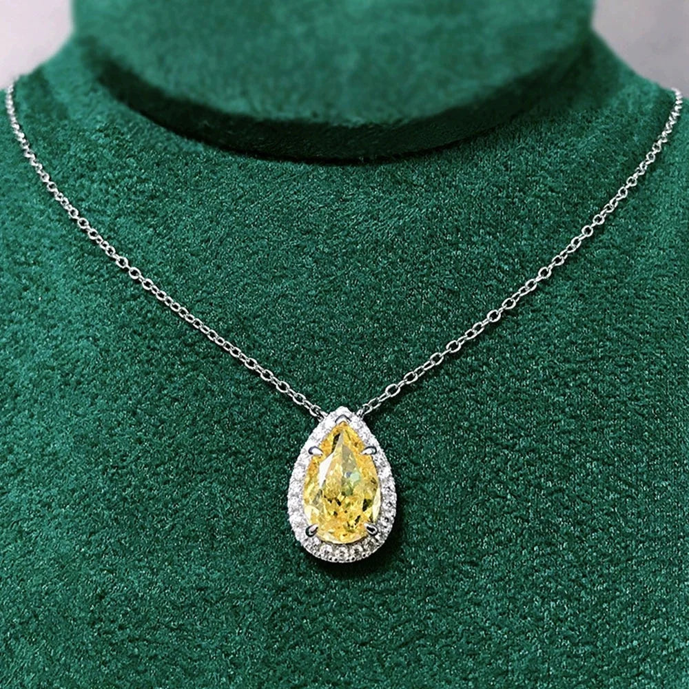 Teardrop-shaped yellow gemstone necklace on a green background