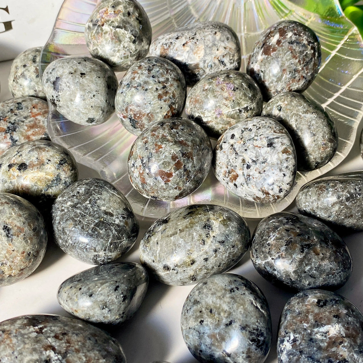 Collection of gray stones on a white surface with a decorative plate in the background