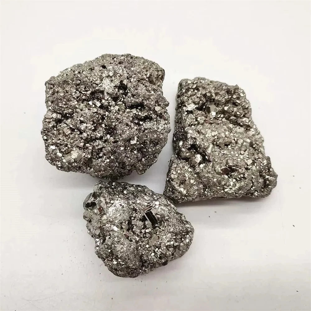 Three metallic pyrite crystals on a white background