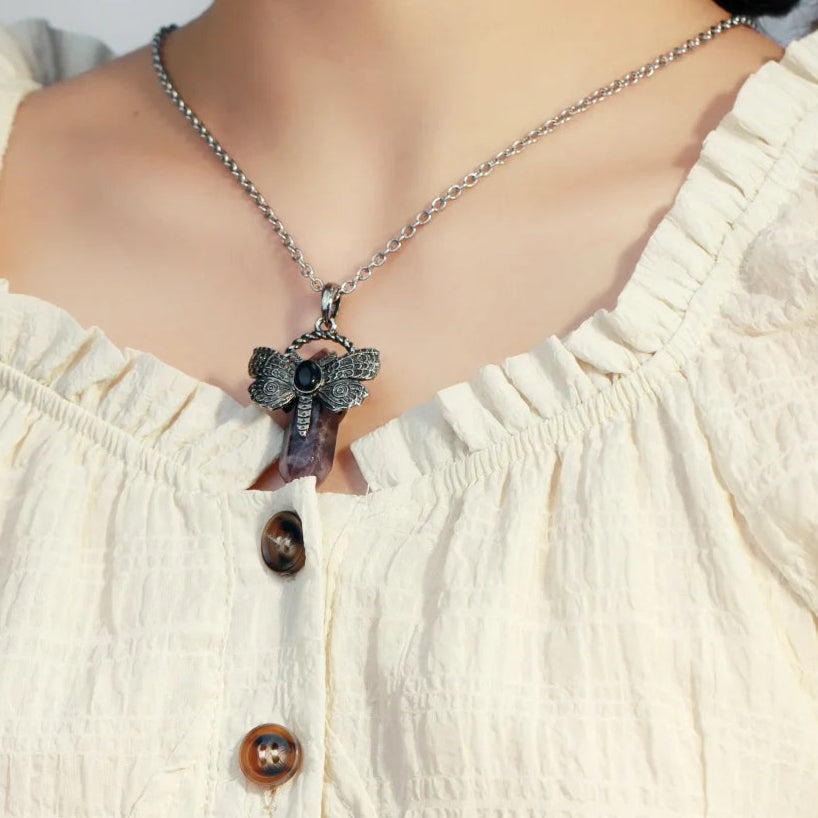Necklace with a pendant worn by a person in a white blouse, with 'CSIA' brand visible.