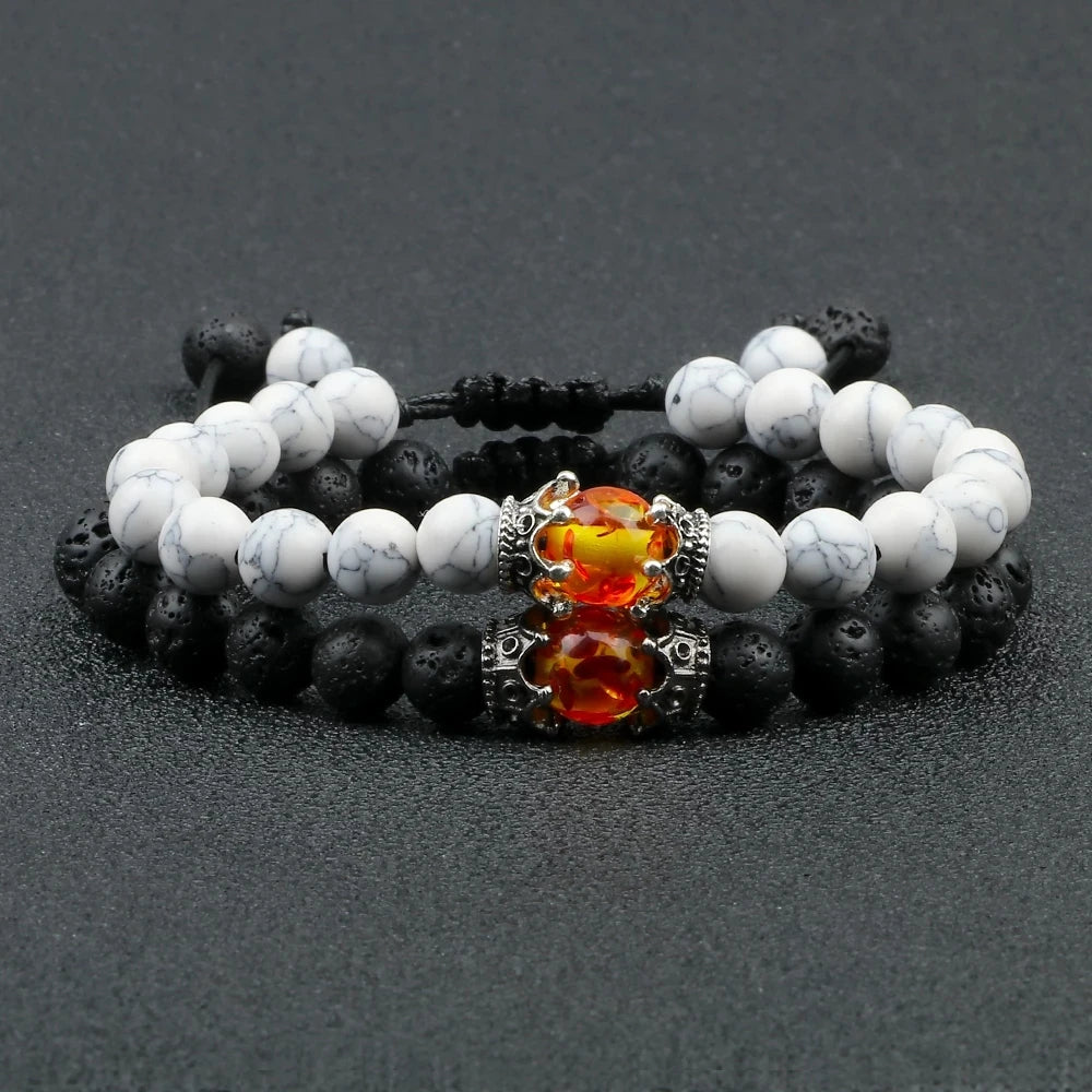 Two beaded bracelets with a central orange gemstone charm on a dark background