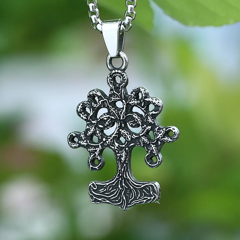 Silver cross pendant necklace against a blurred green background
