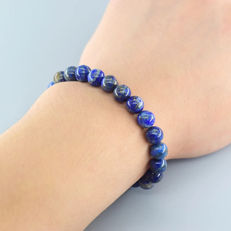 Blue beaded bracelet on a wrist with a light blue background
