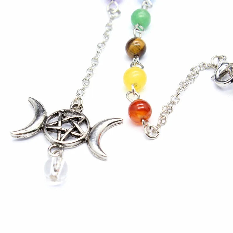 Necklace with silver pentacle and moon design pendant and colorful beads on a white background