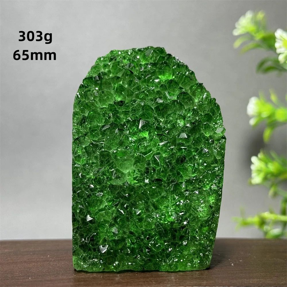 Green crystal rock on a wooden surface with a gray background