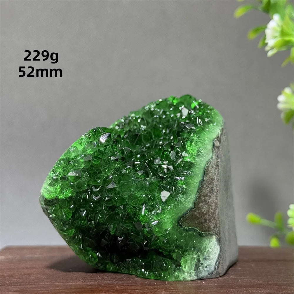Green crystal rock on a wooden surface with measurements displayed.