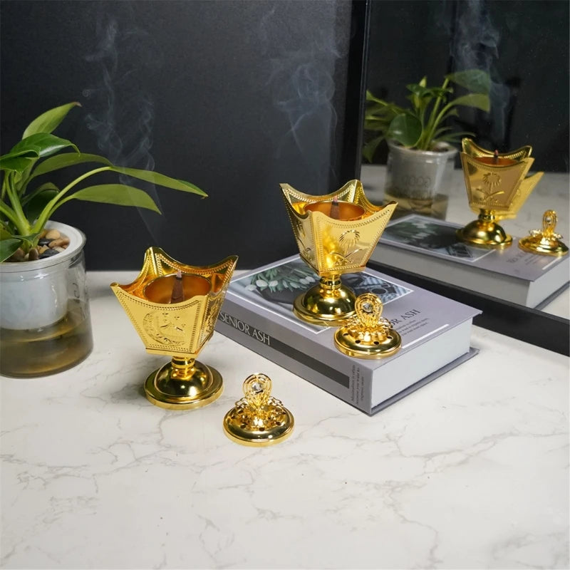 Gold decorative items on a marble surface with a plant and books in the background.