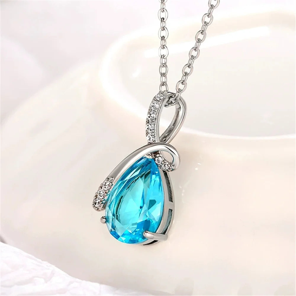 Teardrop-shaped blue gemstone necklace on a white background