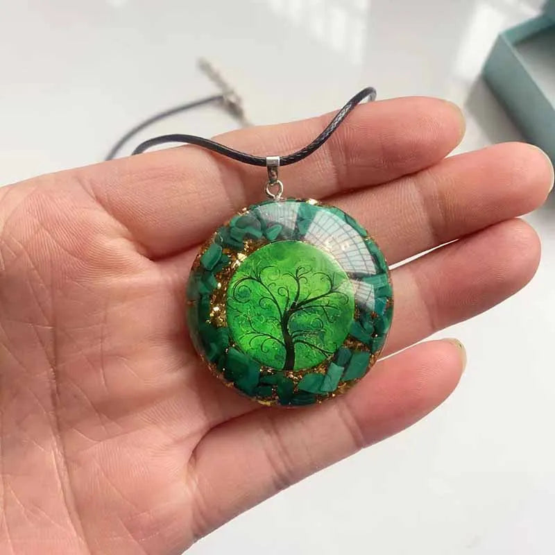 Green tree pendant held in a hand with a white background