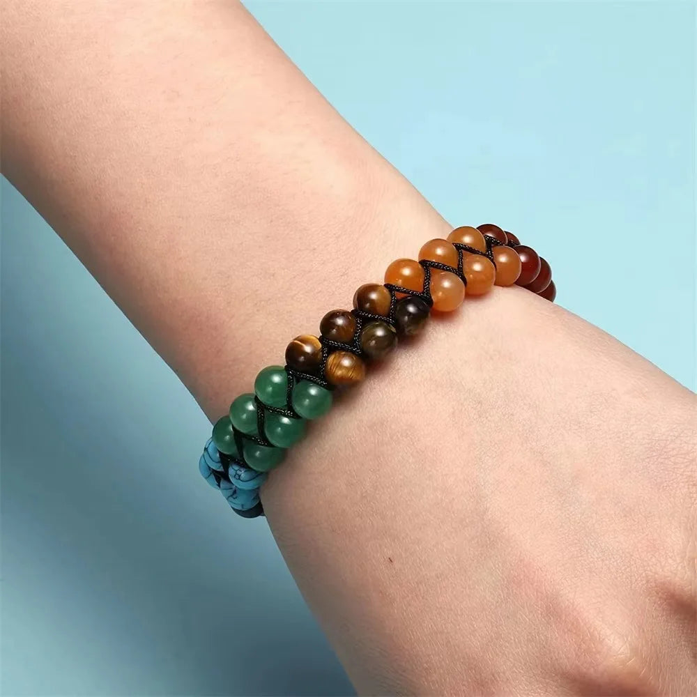 Multicolored beaded bracelet on a wrist against a light blue background