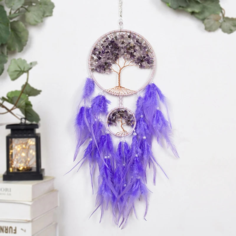 Purple feathered dreamcatcher with tree of life design on a white wall.