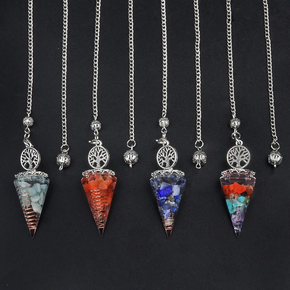 Set of five crystal pendulums on chains against a black background