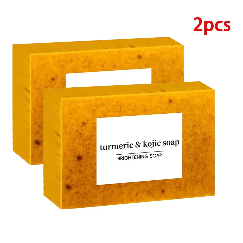 Two pieces of turmeric and kojic soap in a yellow box on a white background