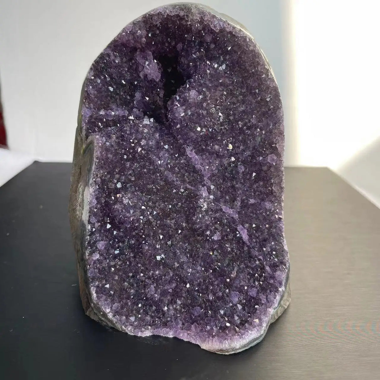 Amethyst crystal on a dark surface with a blurred background