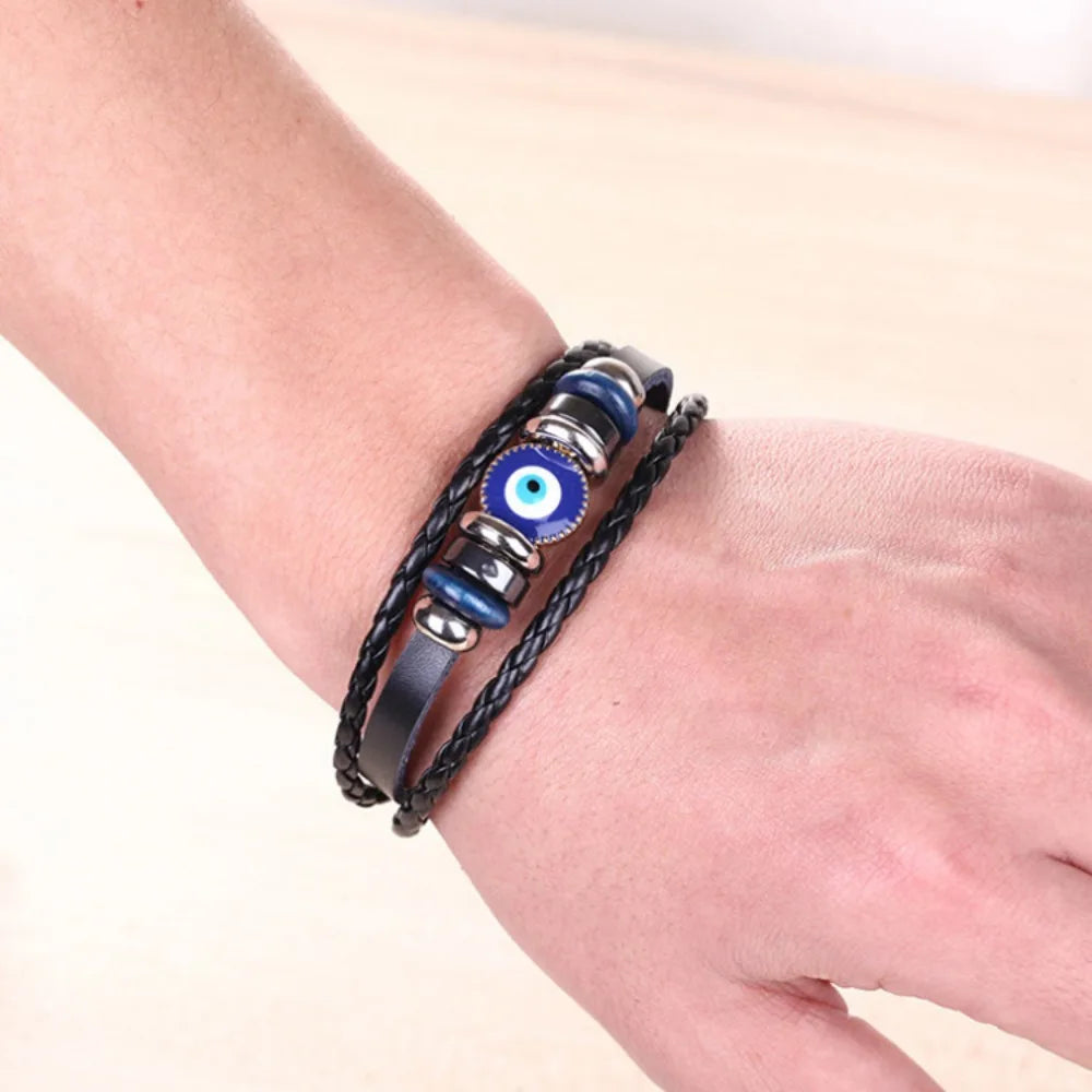 Bracelet with blue evil eye charm on a wrist against a light background