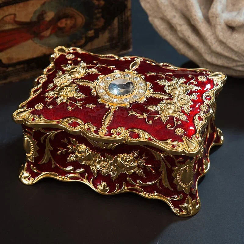 Decorative red and gold box with intricate designs on a dark surface