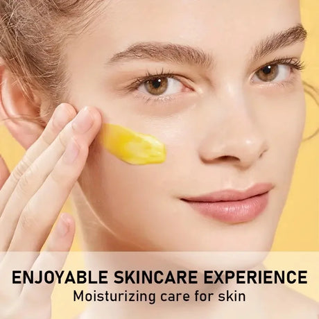Woman applying yellow cream to her face with a yellow background